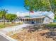 Well-maintained home with a spacious driveway, carport, and an American flag on a sunny day at 1236 Elkhart Cir, Tavares, FL 32778