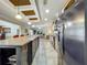 A long galley-style kitchen with an island, stainless steel appliances, and tile flooring at 1236 Elkhart Cir, Tavares, FL 32778