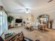 Inviting living room featuring a floral sofa, large TV, and view of the outdoor space at 1236 Elkhart Cir, Tavares, FL 32778