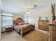 Comfortable main bedroom featuring a unique wooden bed frame, ceiling fan, and ample natural light at 1236 Elkhart Cir, Tavares, FL 32778