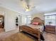 Serene main bedroom with a wooden bed frame, natural light, and an ensuite bathroom at 1236 Elkhart Cir, Tavares, FL 32778