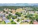 Expansive aerial view of a residential neighborhood with manicured lawns and verdant trees near a lake at 13336 Biscayne Dr, Grand Island, FL 32735