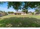 Expansive backyard with lush green grass, mature trees, and a wooden fence for privacy at 13336 Biscayne Dr, Grand Island, FL 32735