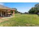 Expansive backyard featuring a covered patio, providing a serene outdoor space at 13336 Biscayne Dr, Grand Island, FL 32735