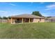 Expansive backyard featuring a covered patio for outdoor enjoyment and a well-maintained lawn at 13336 Biscayne Dr, Grand Island, FL 32735