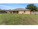 View of the backyard with covered patio, surrounded by a wooden fence at 13336 Biscayne Dr, Grand Island, FL 32735
