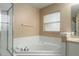Bright bathroom with a soaking tub and a glass-enclosed shower at 13336 Biscayne Dr, Grand Island, FL 32735