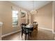 Bright dining room featuring a chandelier, large windows, and a stylish wood dining set at 13336 Biscayne Dr, Grand Island, FL 32735