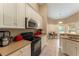 Bright kitchen with white cabinets, tan countertops, and stainless steel appliances with adjacent breakfast nook at 13336 Biscayne Dr, Grand Island, FL 32735
