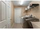 Functional laundry area with modern appliances, sink, and convenient overhead storage at 13336 Biscayne Dr, Grand Island, FL 32735