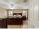 Comfortable main bedroom with a ceiling fan, wood floors, and a large window at 13336 Biscayne Dr, Grand Island, FL 32735