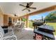 Covered patio featuring ceiling fans, an outdoor dining set, and a barbecue area for outdoor enjoyment at 13336 Biscayne Dr, Grand Island, FL 32735