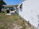 Side view of a modest single-story home with covered parking and sparse landscaping at 1425 County Dr, Tavares, FL 32778