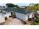 Aerial view of a well maintained home featuring a green roof, two car garage, and lush landscaping at 1482 Azteca Loop, The Villages, FL 32162
