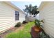 View of landscaped side yard featuring vinyl siding and a well-manicured lawn at 1482 Azteca Loop, The Villages, FL 32162