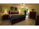 Stylish primary bedroom boasts a ceiling fan, light wood grain floors, and bright colored walls at 1482 Azteca Loop, The Villages, FL 32162
