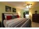 Stylish primary bedroom boasts a ceiling fan, light wood grain floors, and bright colored walls at 1482 Azteca Loop, The Villages, FL 32162