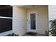 Inviting front entryway with decorative glass door and neutral siding, enhanced by lush landscaping at 1482 Azteca Loop, The Villages, FL 32162
