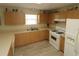 Bright kitchen featuring white appliances, new floors, lots of wood cabinets and countertops at 1482 Azteca Loop, The Villages, FL 32162