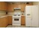 Cozy kitchen featuring white appliances and lots of wood cabinets at 1482 Azteca Loop, The Villages, FL 32162