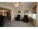 Cozy living room featuring hardwood floors, ceiling fan, comfortable recliner chairs, and views of an adjacent room at 1482 Azteca Loop, The Villages, FL 32162