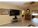 Spacious living area with sleek flooring, modern TV setup, and a stylish side table at 1482 Azteca Loop, The Villages, FL 32162
