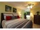 Serene main bedroom featuring a ceiling fan, ensuite bath, a king bed with wood frame, and two dressers for ample storage at 1482 Azteca Loop, The Villages, FL 32162
