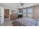 Neutral painted bedroom with ceiling fan, tile floors, two windows, dresser and doorway leading to the living room at 1548 Planters Point Rd, Kissimmee, FL 34744