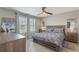 Comfortable bedroom features neutral walls, tile floors, ceiling fan, windows, a dresser, and a bed with a patterned bedspread at 1548 Planters Point Rd, Kissimmee, FL 34744