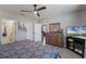 Bedroom showcases tile flooring, ceiling fan, television, doorway and a closet on the way to the bathroom at 1548 Planters Point Rd, Kissimmee, FL 34744