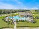Aerial view of a large community pool area featuring palm trees, lounge chairs, and a clubhouse at 1548 Planters Point Rd, Kissimmee, FL 34744
