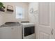 Well-lit laundry room equipped with a modern washer and dryer, complemented by stylish decor at 1548 Planters Point Rd, Kissimmee, FL 34744