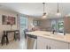 Open-concept living space featuring island seating, stainless steel appliances, and comfortable living area at 1548 Planters Point Rd, Kissimmee, FL 34744