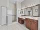 Bathroom featuring double sinks, a large mirror, and a glass door shower at 17471 Se 110Th Ter, Summerfield, FL 34491