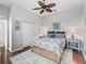 Well-lit bedroom featuring hardwood floors, a ceiling fan, and a queen bed at 17471 Se 110Th Ter, Summerfield, FL 34491
