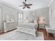 Bright bedroom featuring hardwood floors, a ceiling fan, and a full dresser with a mirror at 17471 Se 110Th Ter, Summerfield, FL 34491