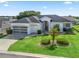 Beautiful single-story home with well-manicured lawn, mature landscaping, and two-car garage on a sunny day at 17471 Se 110Th Ter, Summerfield, FL 34491