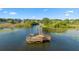 Scenic aerial shot of a wooden dock and sitting area stretching into a calm waterway surrounded by trees at 19627 Spring Oak Dr, Eustis, FL 32736