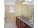 Bathroom with double sinks, wood cabinets, and tile floors at 19627 Spring Oak Dr, Eustis, FL 32736