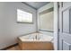 Bathroom featuring a tiled, corner soaking tub and a window with blinds at 19627 Spring Oak Dr, Eustis, FL 32736