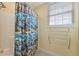 Bright bathroom features a shower with fun surf themed curtain, a window and towel wrack at 19627 Spring Oak Dr, Eustis, FL 32736