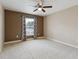 Spacious carpeted bedroom with a ceiling fan, window with curtains, and a warm, neutral color palette at 19627 Spring Oak Dr, Eustis, FL 32736
