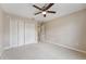 Bright, carpeted bedroom with a ceiling fan and a closet with white doors at 19627 Spring Oak Dr, Eustis, FL 32736