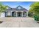 Attractive two-story blue house with white trim, pillars and a long driveway at 19627 Spring Oak Dr, Eustis, FL 32736