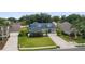 Charming two-story home with vibrant blue exterior, lush lawn, mature trees, and long driveway at 19627 Spring Oak Dr, Eustis, FL 32736