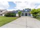 Charming blue two-story home featuring a well-manicured lawn and a long driveway at 19627 Spring Oak Dr, Eustis, FL 32736