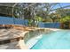 An inviting screened-in pool with a charming waterfall feature and stone accents at 19627 Spring Oak Dr, Eustis, FL 32736
