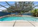 Beautiful backyard pool with a tranquil waterfall feature under a screened enclosure at 19627 Spring Oak Dr, Eustis, FL 32736
