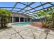 Backyard pool with a rock patio, lush landscaping, and covered patio area at 19627 Spring Oak Dr, Eustis, FL 32736
