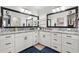 Bright bathroom features double sinks, granite countertops, white cabinetry, large mirrors and modern lighting at 2015 Palo Alto Ave, The Villages, FL 32159